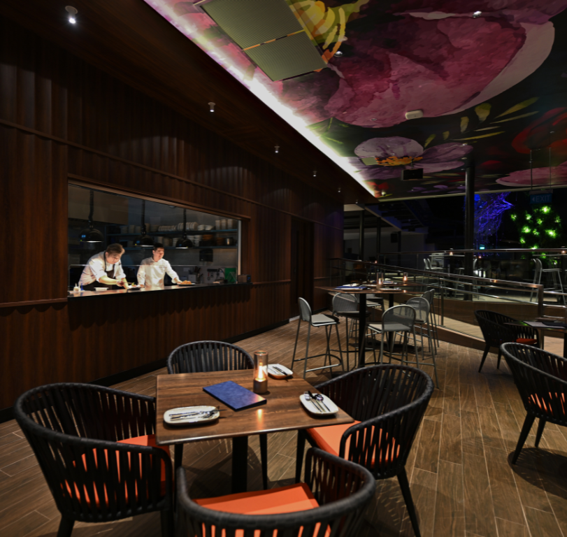 Indoor seating at Dusk Restaurant Mount Faber Peak featuring show kitchen and 2 chefs