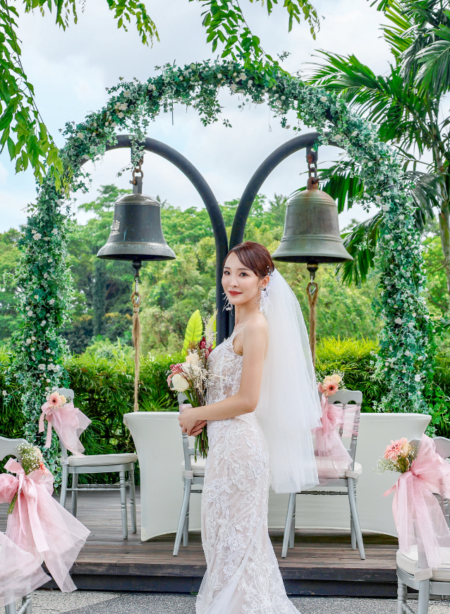 Bride standing holding flowers at Arbora Mount Faber Peak solemnisation ceremony, with Poland's Bells of Happiness